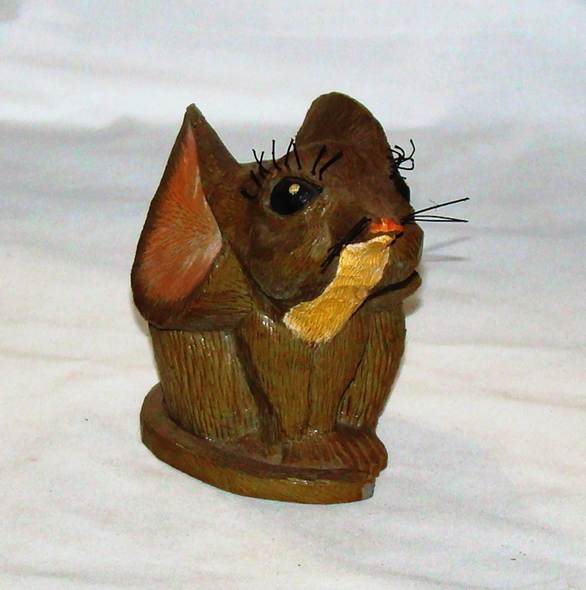 A wooden mouse figurine on a white surface

AI-generated content may be incorrect.