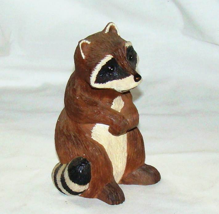 A raccoon figurine on a white surface

AI-generated content may be incorrect.