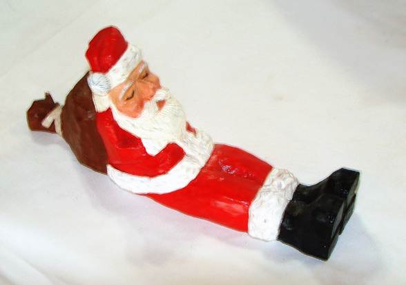 A santa claus figurine lying down

AI-generated content may be incorrect.