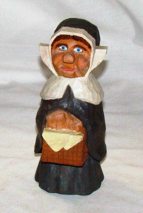 A wooden figurine of a nun holding a basket

AI-generated content may be incorrect.