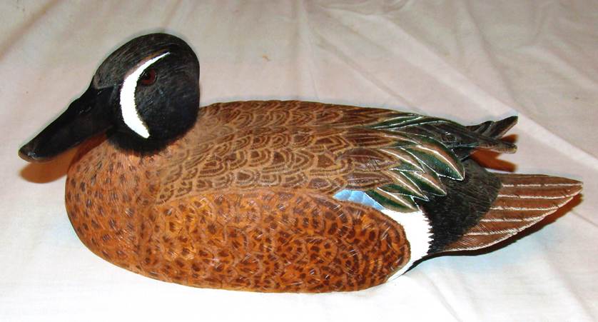 A wooden duck sculpture on a white surface

AI-generated content may be incorrect.