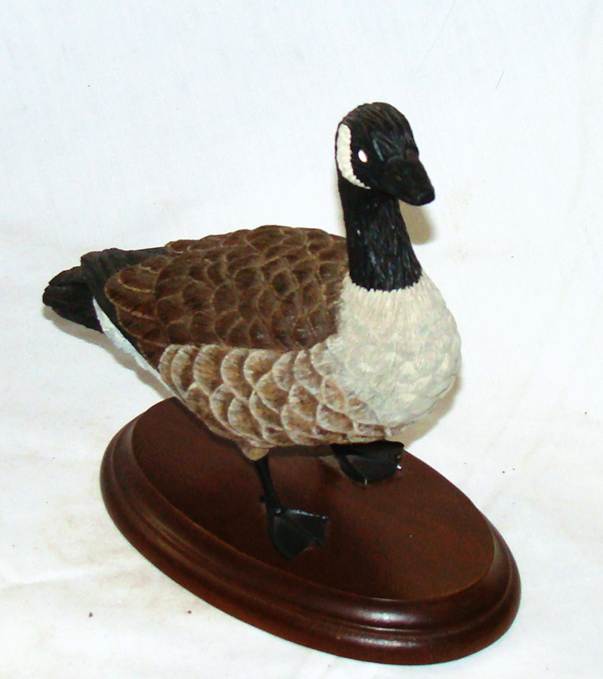 A statue of a goose on a wooden stand

AI-generated content may be incorrect.