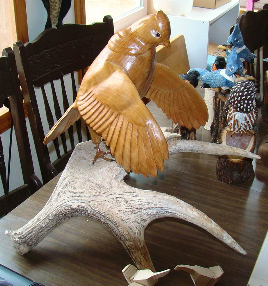 A wooden bird sculpture on a table

AI-generated content may be incorrect.