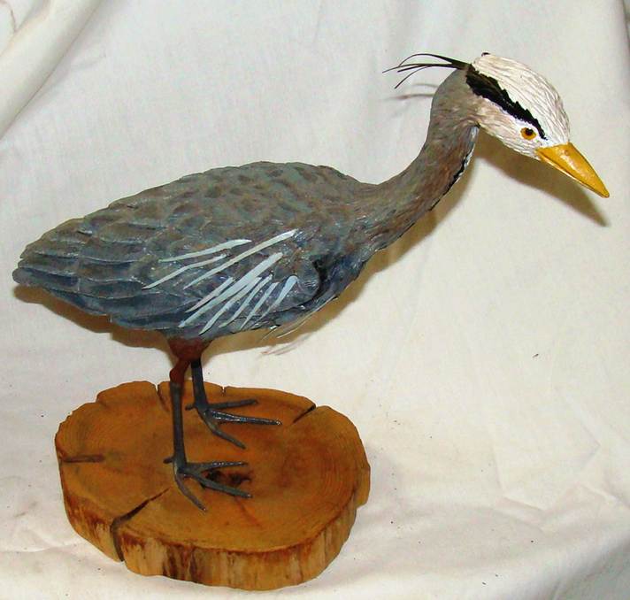 A bird statue on a piece of wood

AI-generated content may be incorrect.