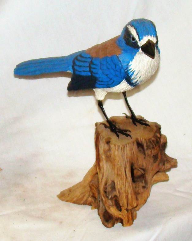 A bird statue on a piece of wood

AI-generated content may be incorrect.