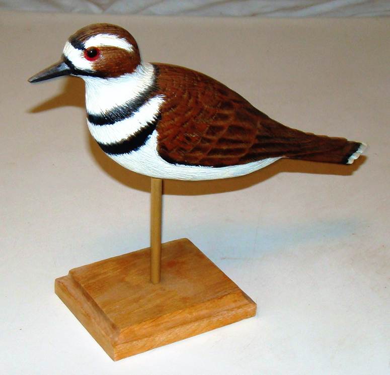 A wood bird on a stand

AI-generated content may be incorrect.