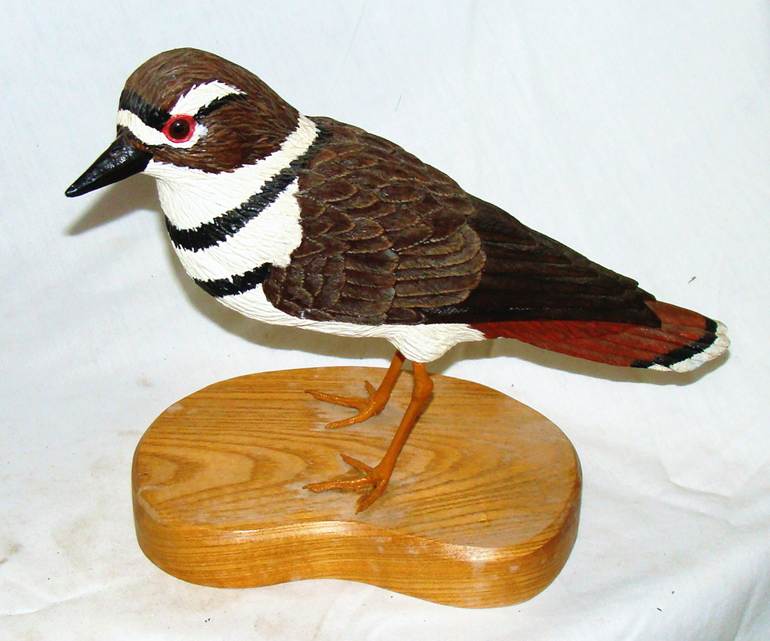 A wood bird on a wooden stand

AI-generated content may be incorrect.