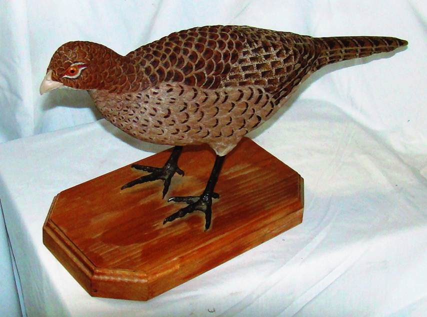 A wood bird sculpture on a white surface

AI-generated content may be incorrect.