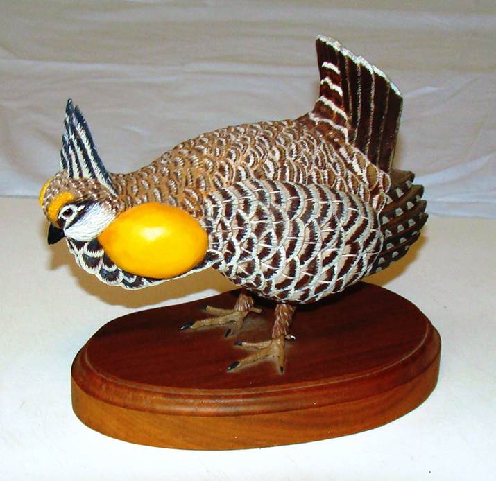 A statue of a bird with a yellow object on a wooden stand

AI-generated content may be incorrect.