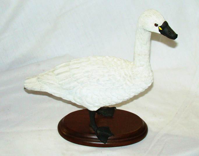 A white goose statue on a wooden stand

AI-generated content may be incorrect.