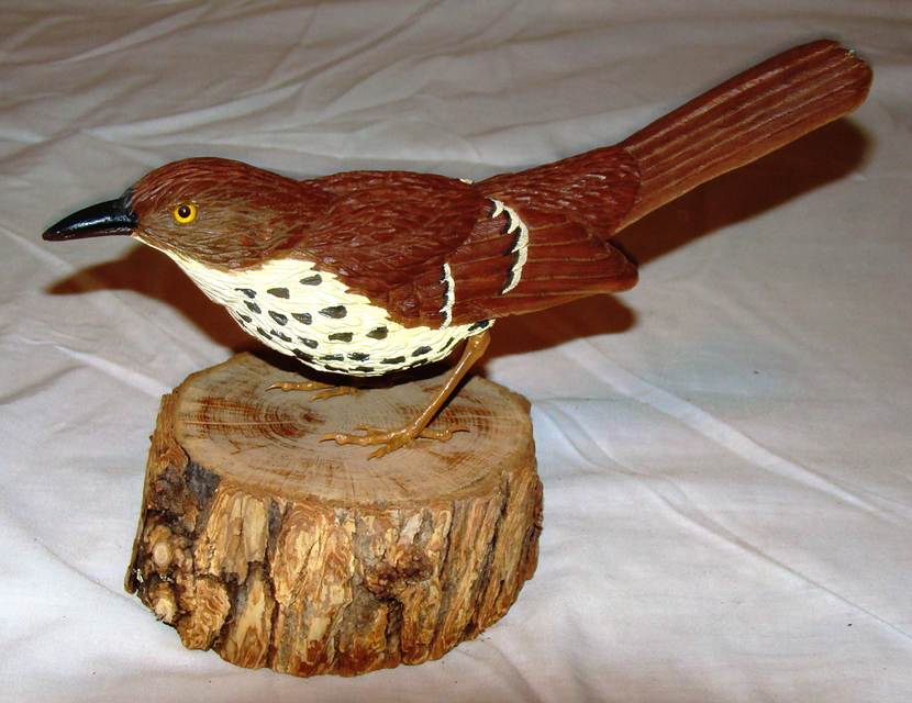 A wood bird on a piece of wood

AI-generated content may be incorrect.