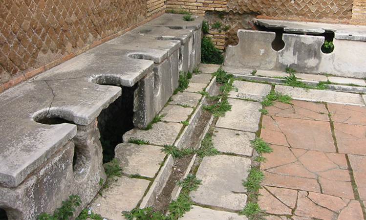 A row of ancient stone toilets in Rome